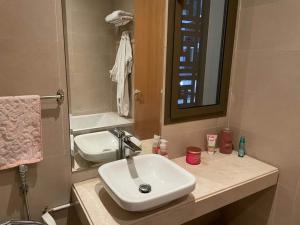 塞拉Appartement a la marina de salé的浴室设有白色水槽和镜子