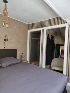 贝克贝亨Logeren bij Sabine en JW的卧室配有床、椅子和窗户。