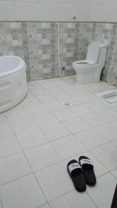 麦地那Traveler Rooms 2的浴室楼层配有一双拖鞋和卫生间