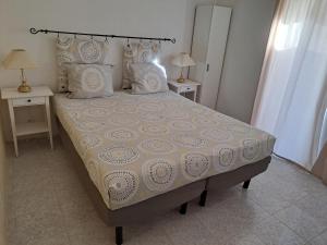 波尔蒂芒Casa Rochinha的卧室内的一张床位,配有两张桌子和两盏灯