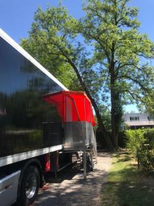 苏黎世Sleeptrailer的停在树旁边的一辆红色卡车