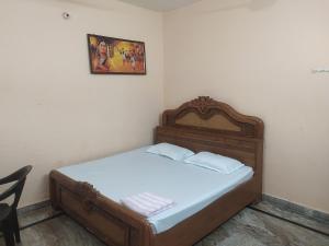 奥拉奇哈Orchha Best Homestay的卧室内的一张床铺,墙上挂着一幅画