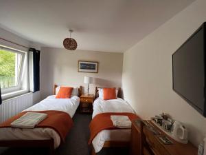 德拉姆纳德罗希特Rooms at Elmbank near Loch Ness的酒店客房设有两张床和一台平面电视。