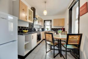 泰恩河畔纽卡斯尔Newcastle CITY Apartments 35的厨房配有桌椅和冰箱。