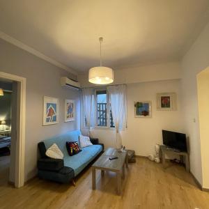 雅典Cozy apartment ideally located city center and Megaron Moussikis metro station的客厅配有蓝色的沙发和桌子