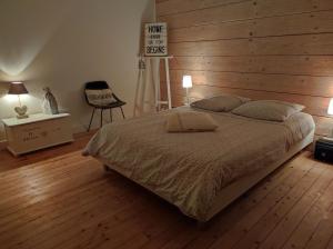 勒芒Chambres d'hôtes de charme sur LE MANS的一间卧室设有一张床和木墙
