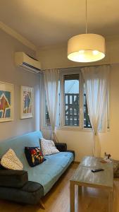 雅典Cozy apartment ideally located city center and Megaron Moussikis metro station的客厅配有蓝色的沙发和桌子