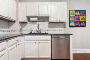 堪萨斯城Historic Family Getaway, 5 Star Location, Royal Beds的厨房配有白色橱柜和不锈钢洗碗机。