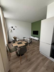 莱顿Da Costa 12A的配有桌椅和电视的客房