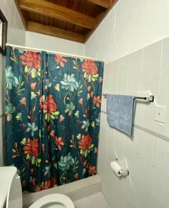 圣卡洛斯Inti Wasi的浴室设有花卉图案的浴帘