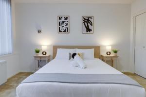 阿林顿Sensational Condominium @Crystal City的卧室配有一张带两张桌子的大型白色床