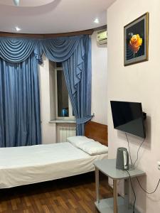 埃里温Manand Hotel的小房间设有床铺和电视