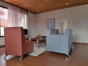 埃雷迪亚видовая квартира в Heredia的客厅配有两把椅子和一张桌子