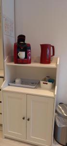 汉诺威法姆洪内夫公寓的白色的橱柜,上面有咖啡壶