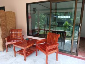 高兰班长滩旅馆的客房设有两把椅子、一张木桌、一张桌子和玻璃窗。