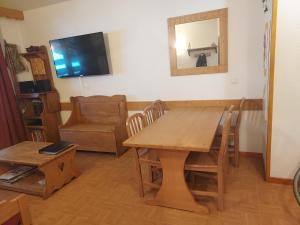 莱德萨阿尔卑斯T3 Les deux Alpes Vallée Blanche的客厅配有木桌和椅子