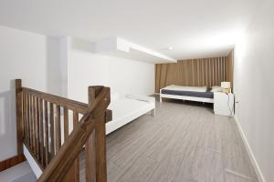 兹林Block 96 Apartments的一间卧室设有一张床和木制楼梯。
