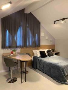 波梅罗迪Loft do Vale的卧室配有一张床,窗户前设有一张桌子