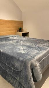 波梅罗迪Loft do Vale的一间卧室配有一张床铺,床上铺有灰色的毯子
