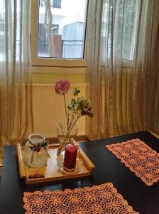 塞萨洛尼基Virginia Apartment的一张桌子,上面有一个带花瓶和蜡烛的托盘