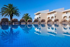 里科索翁Argile Resort & Spa的棕榈树酒店前的游泳池