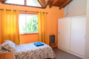 圣卡洛斯-德巴里洛切Casa Maiten 2 dormitorios的一间卧室设有一张床和一个窗口