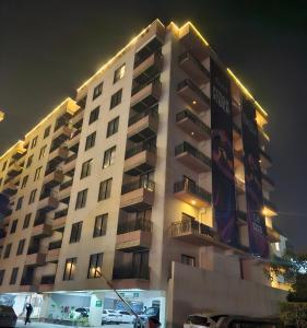拉瓦尔品第Aesthetic Scenic Luxurious Apartment - Bahria Heights的一座高大的公寓楼,晚上有灯