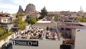 乌奇希萨尔Stone Owl Otel的一群人坐在大楼的阳台上