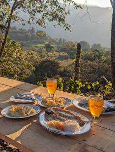 MacanalMamaterra Glamping的餐桌,带食物盘和橙汁杯