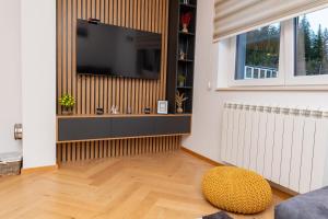 亚霍里纳Sunčani vrhovi的客厅设有壁挂式平面电视。