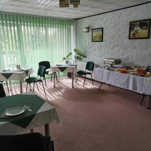 科贝拉古拉Usługi Noclegowe i Gastronomiczne dla Ludności Robert Mielcarek的用餐室配有桌椅和绿色窗帘