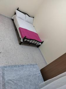 阿布扎比Hussaini Home的一间卧室配有一张带粉色和白色毯子的床