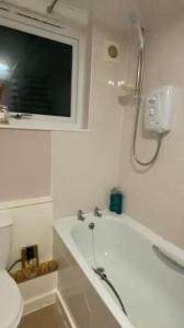 曼彻斯特Lovely, spacious 1-bedroom apartment with *free parking的带浴缸、淋浴和卫生间的浴室