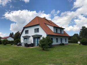 ZudarDycke Haus 6的一座白色的房子,在田野上有一个橙色的屋顶
