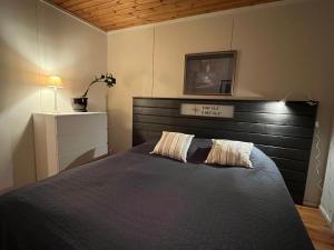 波尔沃Tirmo Strand的一间卧室配有一张大床和木制床头板