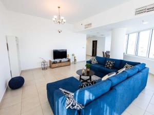 迪拜Avantha By Afi luxury 2BHK apartment的客厅配有蓝色的沙发和电视