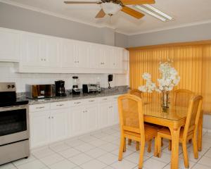 特古西加尔巴贵雅洛斯公寓式酒店的厨房配有带椅子的木桌和桌子。