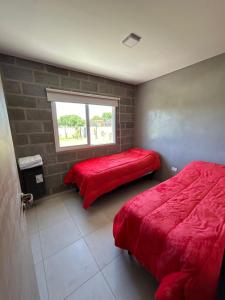 General RocaCasa en el rio的一间卧室设有两张床和窗户。