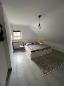 萨尔布吕肯Ferienwohnung am Grumbach的一间卧室设有床、窗户和地毯。