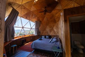 Puerto CorralHuiro Lodge的卧室配有木制天花板上的床铺