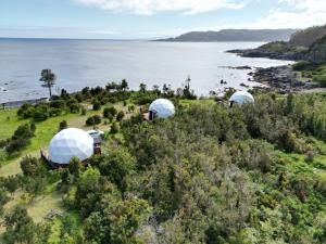 Puerto CorralHuiro Lodge的近海山丘上三个圆顶的空中景观