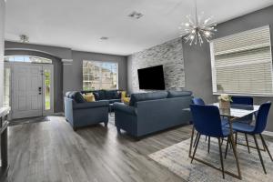 奥兰多Themed Luxury 6BR Getaway with Resort Amenities的客厅配有蓝色的沙发和电视
