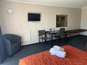 哈士汀苹果汽车旅馆 的酒店客房设有床、桌子和电视。