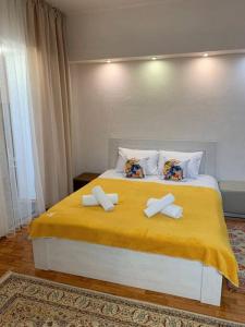 阿拉木图Уют в деловом центре Алматы的一间卧室配有一张带黄色床单和枕头的床。