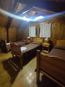 坎伯雷塔La cumbrecita village的一间卧室设有两张床,天花板上拥有灯光