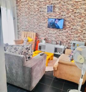 基苏木Beautiful and Affordable 1brm in Milimani的客厅设有两张沙发和砖墙