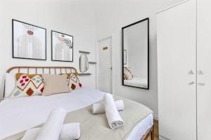 伦敦Cosy place near Camden town的卧室配有一张带镜子的大型白色床