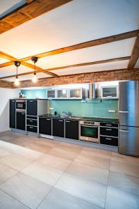 吕德斯海姆Designhaus - Whirlpool - 180qm2 - Garage - 2 Etagen的厨房配有黑色橱柜和不锈钢用具