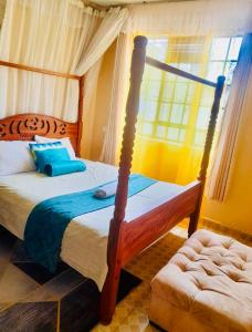 基苏木Beautiful and Affordable 1brm in Milimani的一间卧室设有四柱床和窗户。