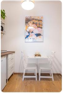 米兰Casa Rizzoli - bilocale vicinissimo M2的厨房配有白色的桌子和两把椅子